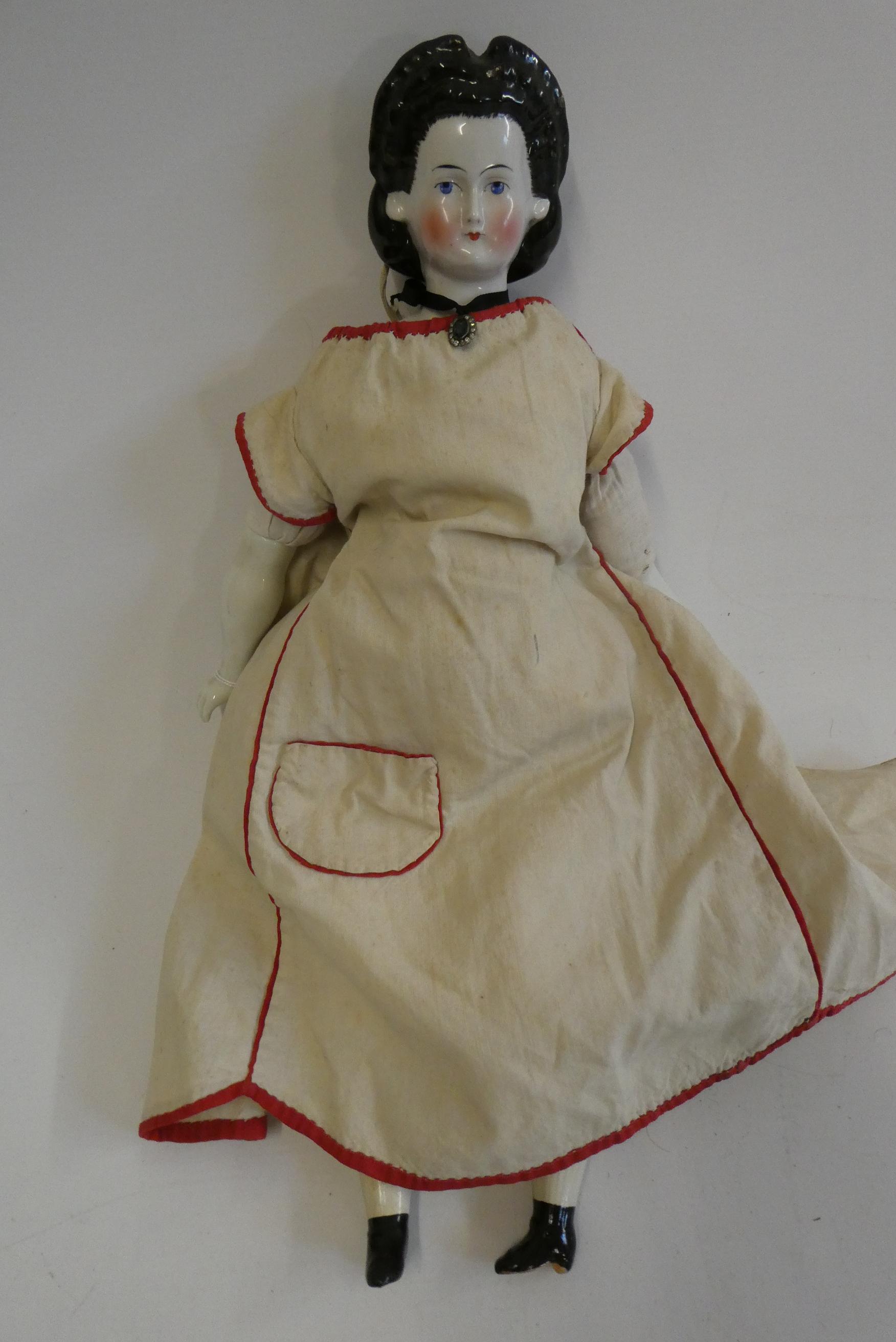 A china shoulder head doll, c.1880, with moulded hair, painted features, china lower limbs, moulded Image