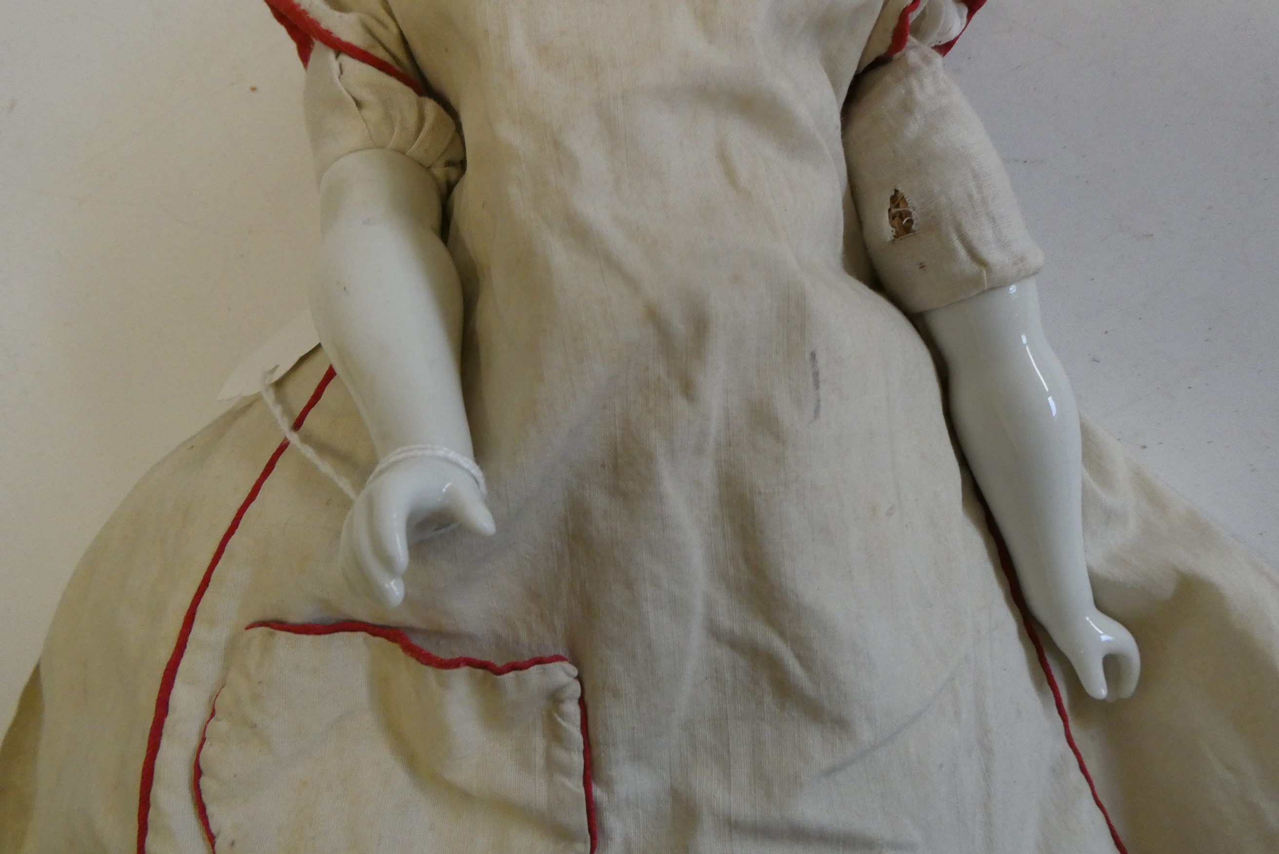 A china shoulder head doll, c.1880, with moulded hair, painted features, china lower limbs, moulded Image