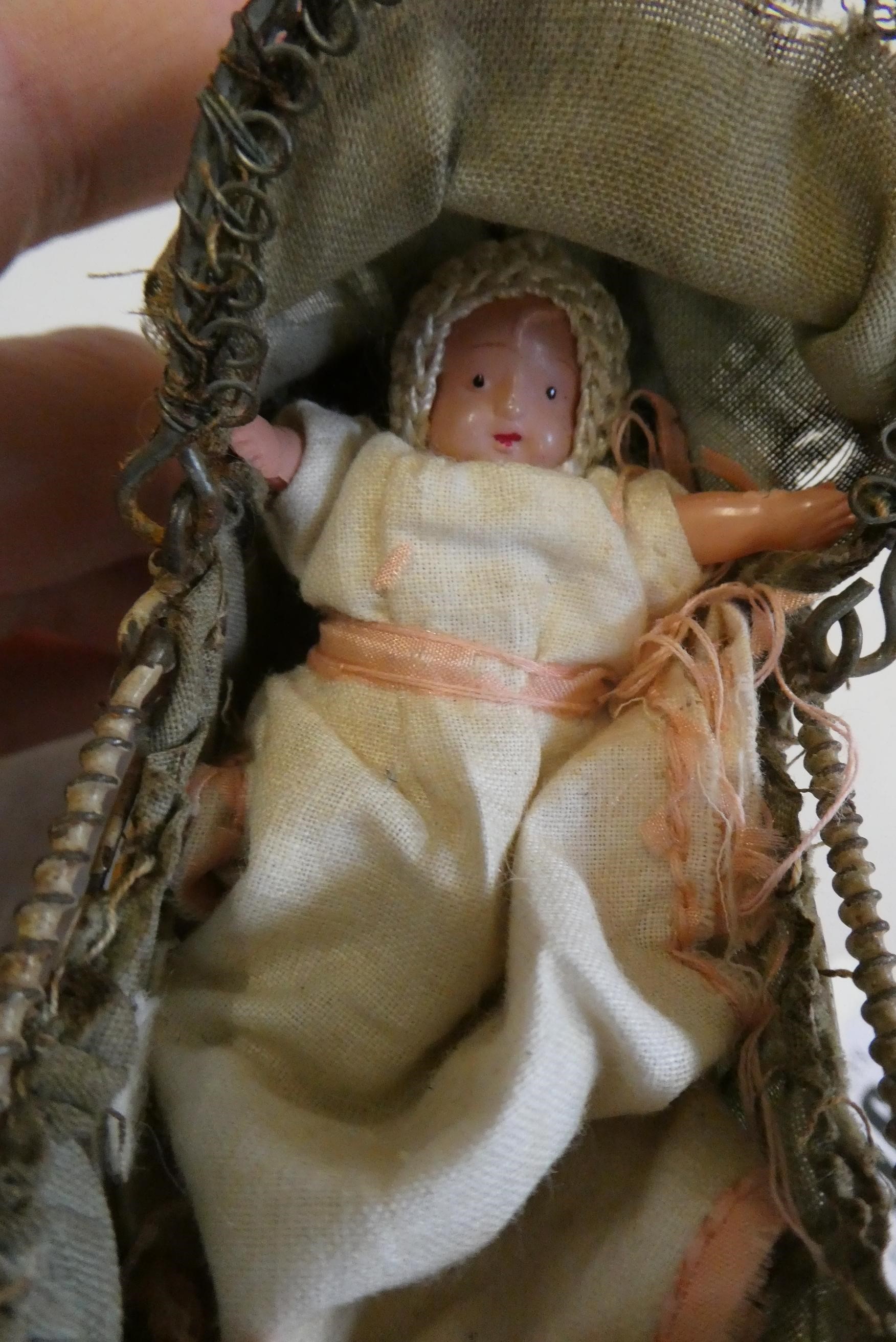 A pre-war filigree dolls house pram, with fabric hood and liner, 4 1/2" long, together with a Image