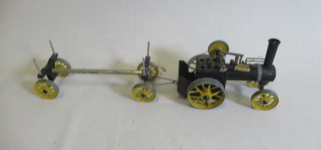 A Mamod steam traction engine and log wagon finished in black and yellow Image