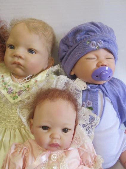 Four dolls comprising a Lee Middleton Reva doll and three Ashton Drake dolls Image