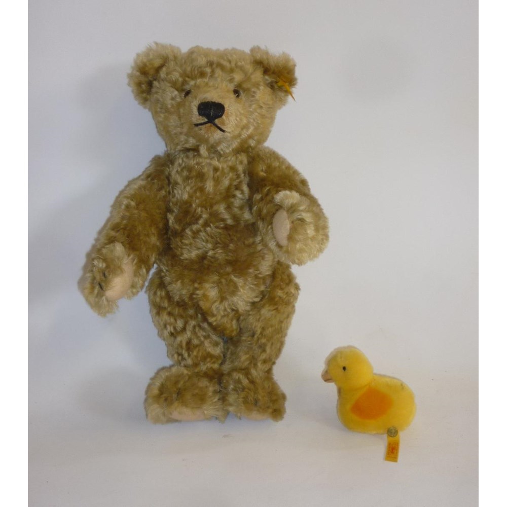 A Steiff replica teddy bear in pale gold plush with growl and button to ear Image