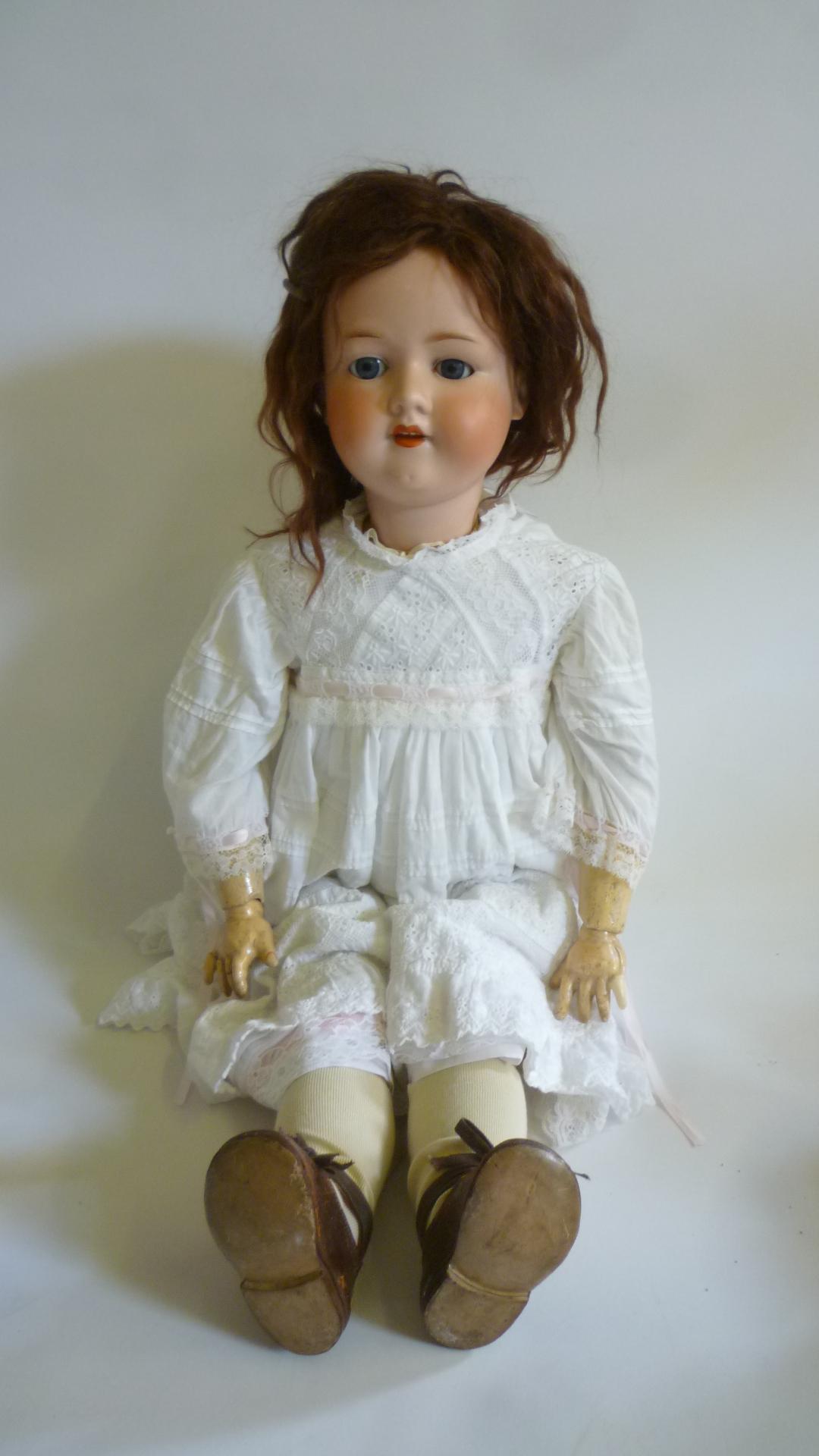An Armand Marseille bisque head doll with blue glass sleeping eyes Image