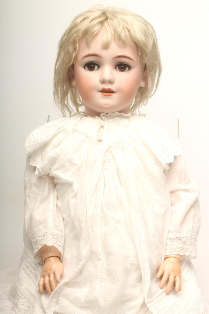 A Simon & Halbig bisque head doll with brown glass sleeping eyes Image