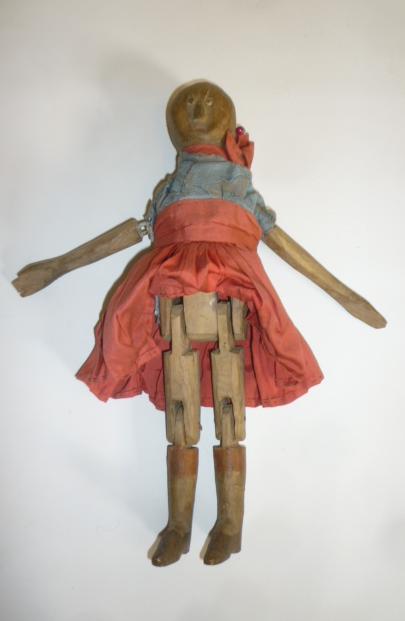 A carved wood doll Image