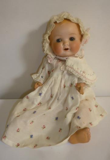 An Armand Marseille bisque head baby doll with blue glass sleeping eyes Image