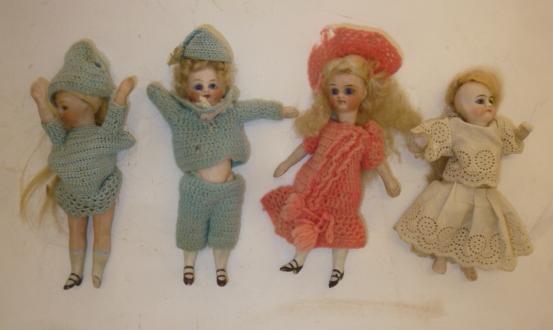 Four bisque head dolls' house dolls with fixed blue glass eyes Image