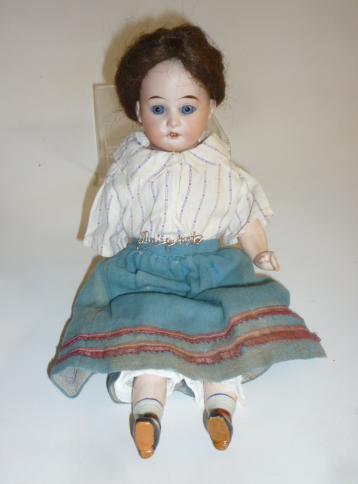 A Cuno & Otto Dressel bisque shoulder head doll with fixed blue glass eyes Image