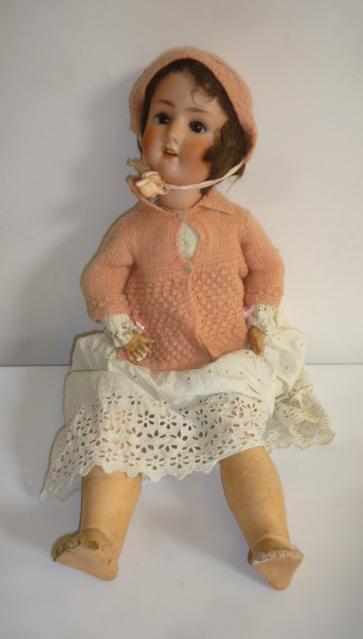 A Schoenau & Hoffmeister bisque head doll with brown glass sleeping eyes Image