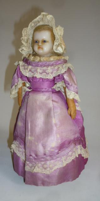 A wax shoulder head automaton doll with fixed blue glass eyes Image