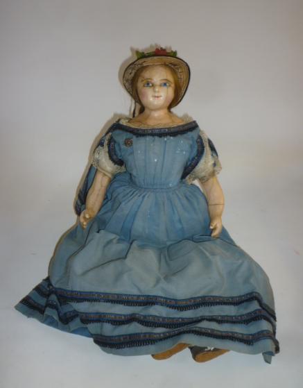 A wax shoulder head doll with fixed blue glass eyes Image