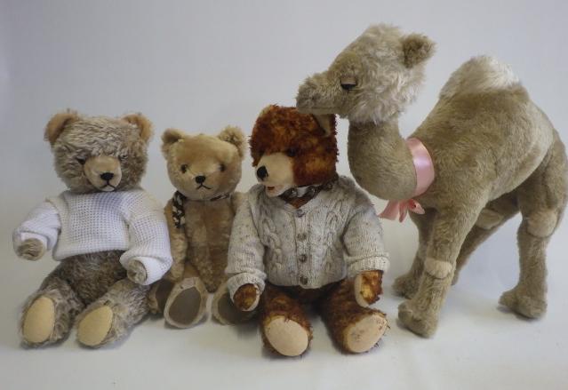 Four stuffed animals comprising a large camel Image