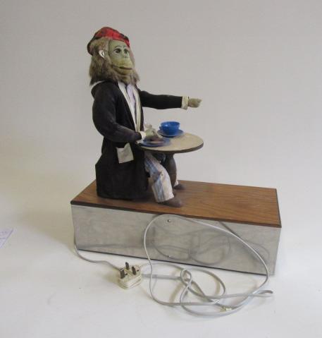 An electrically driven monkey automaton in dressing gown and pyjamas seated at a table Image