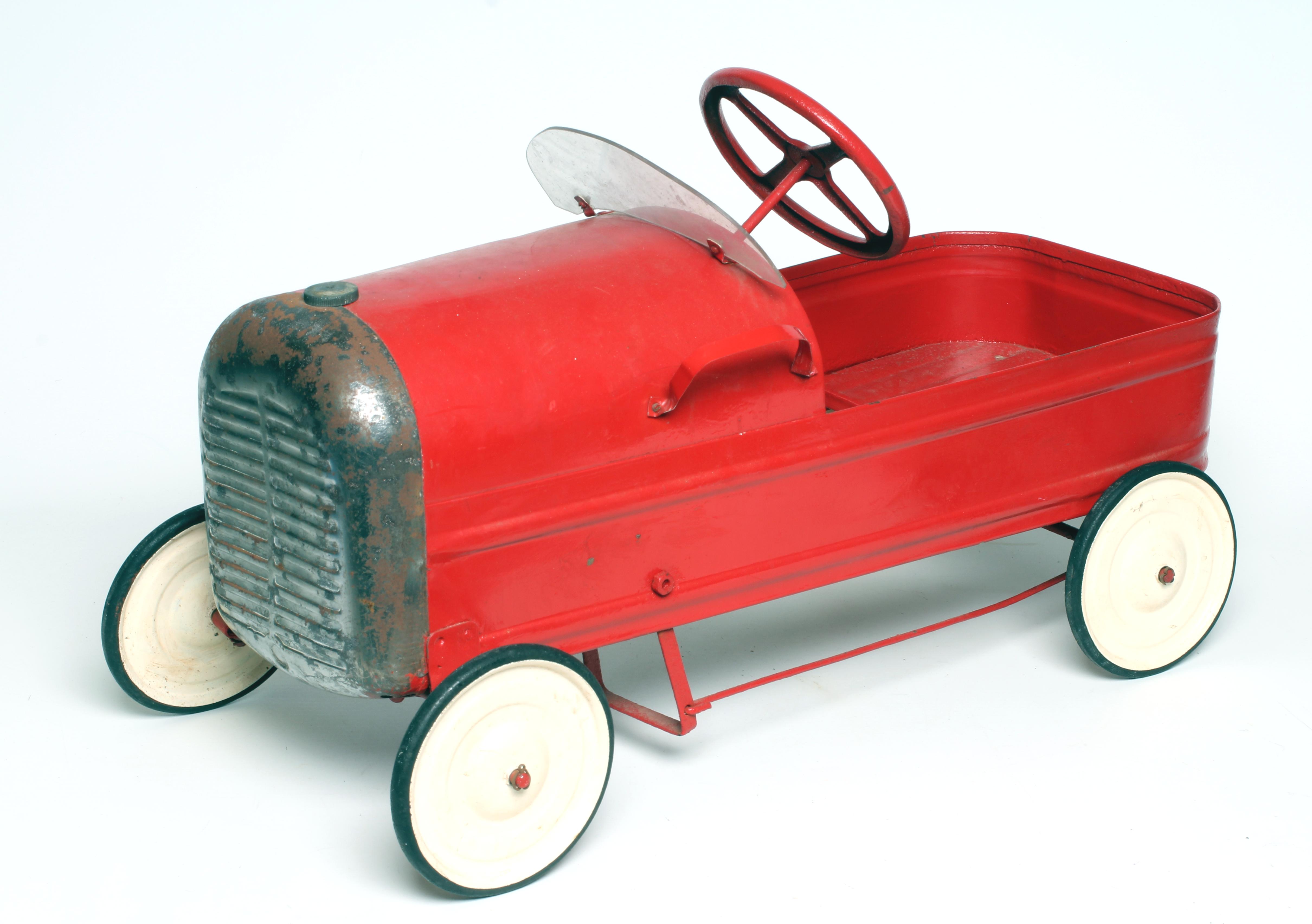 A Triang type pedal car finished in red with white wheels Image