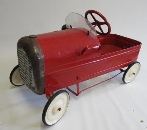 A Triang type pedal car finished in red with white wheels Image