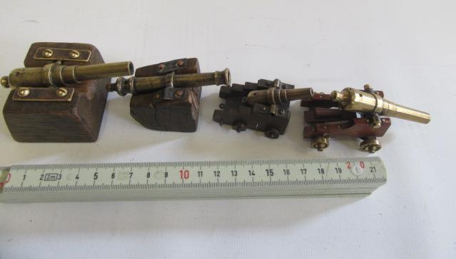 Four antique miniature brass cannons affixed to wooden bases Image