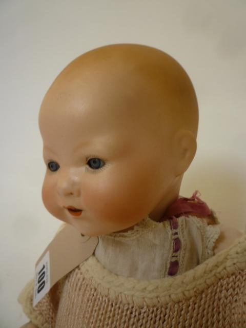 An Armand Marseille bisque head baby doll with blue glass sleeping eyes Image