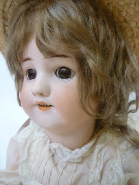 A Simon & Halbig bisque head girl doll with brown glass sleeping eyes Image