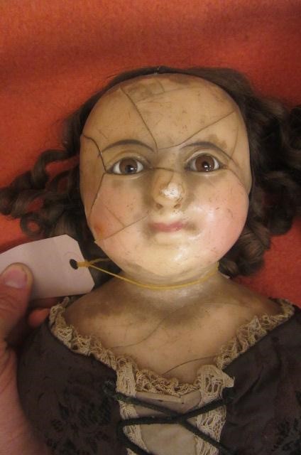 A wax shoulder head doll with fixed brown glass eyes Image
