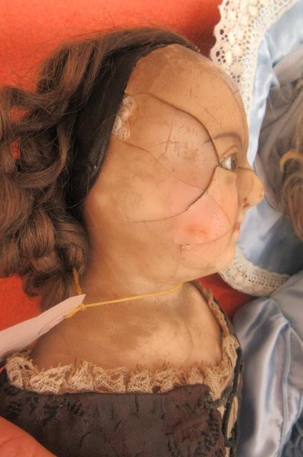 A wax shoulder head doll with fixed brown glass eyes Image