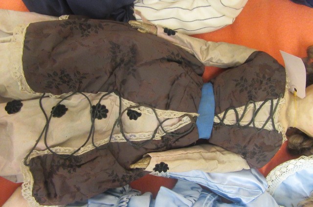 A wax shoulder head doll with fixed brown glass eyes Image