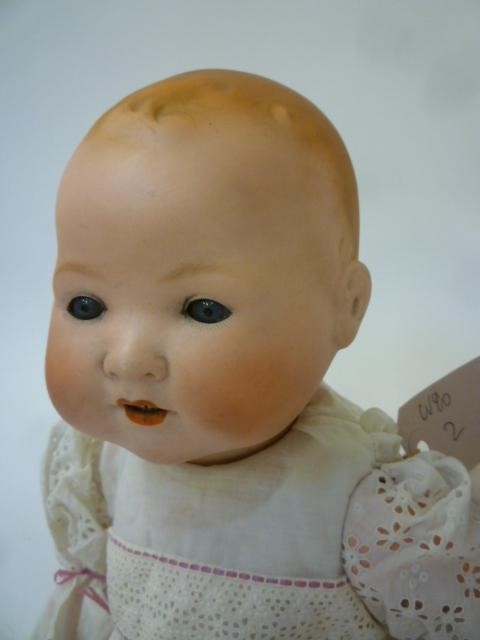 An Armand Marseille bisque head baby doll with blue glass sleeping eyes Image