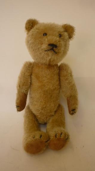 An early 20th century teddy bear covered in fawn plush with show button eyes Image