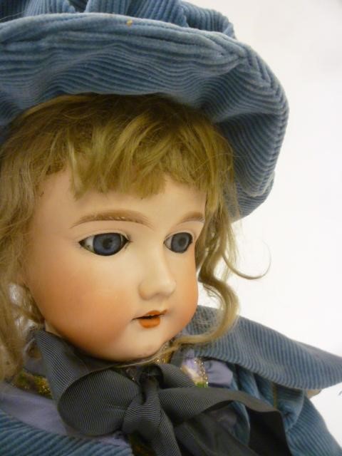 An Armand Marseille bisque head doll with blue glass sleeping eyes Image