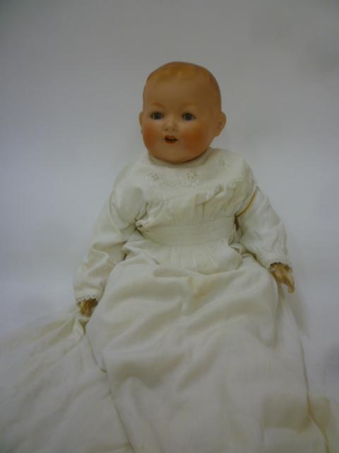 An Armand Marseille bisque head baby doll with blue glass sleeping eyes Image