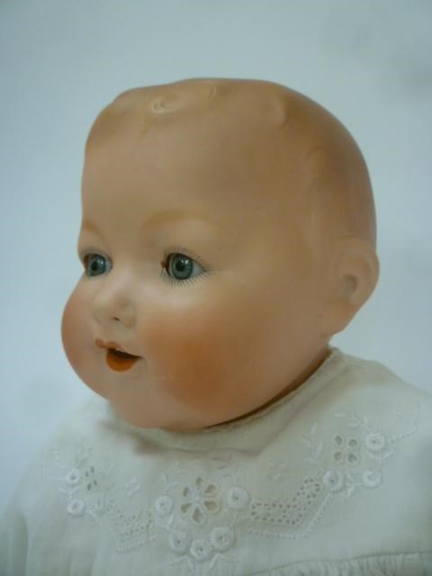 An Armand Marseille bisque head baby doll with blue glass sleeping eyes Image