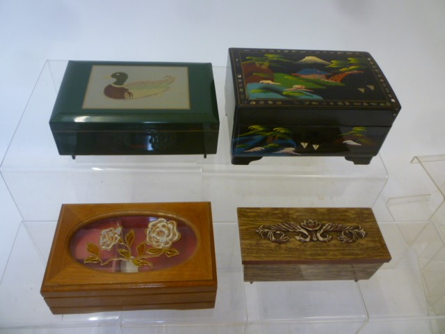 Four musical jewel boxes comprising a black lacquered and painted wood box with dancing lady Image
