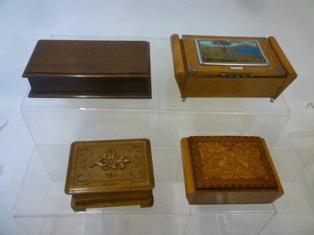 Four musical cigarette boxes comprising a beechwood scroll ended box Image