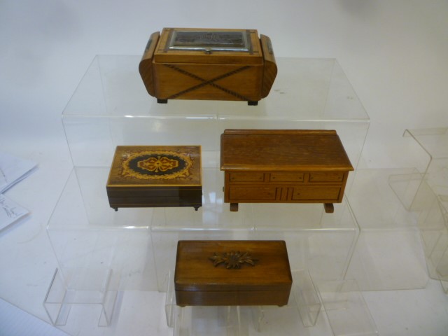 Four musical cigarette boxes comprising an inlaid beechwood box Image