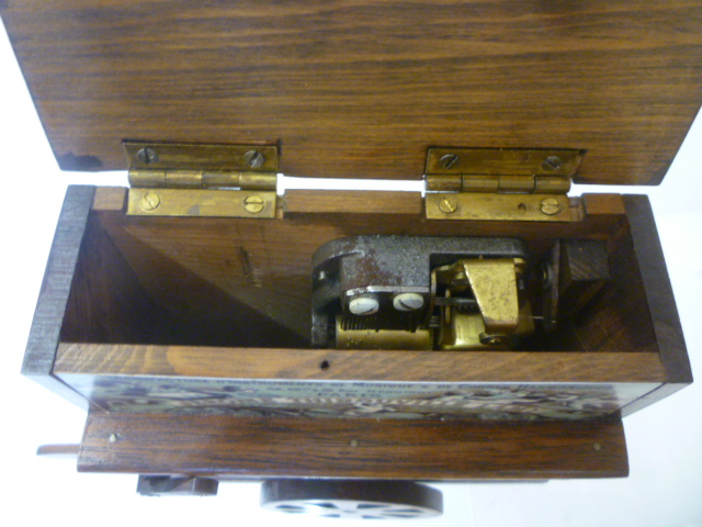 Three musical items comprising a barrel organ in stained wood case with printed panels Image