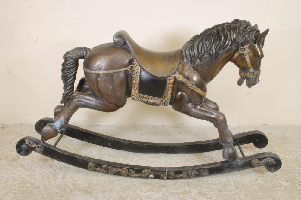 A cast bronze rocking horse garden ornament with integral saddle and harness and bow rockers with Image