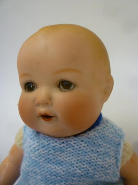 An Armand Marseille bisque head baby doll with brown glass sleeping eyes Image