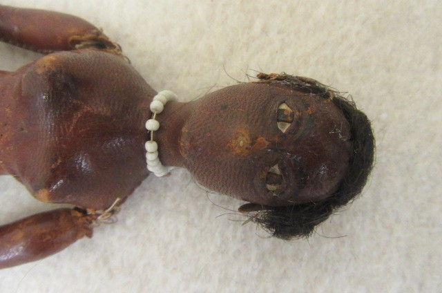 An early 19th century stitched leather doll with inset painted eyes Image