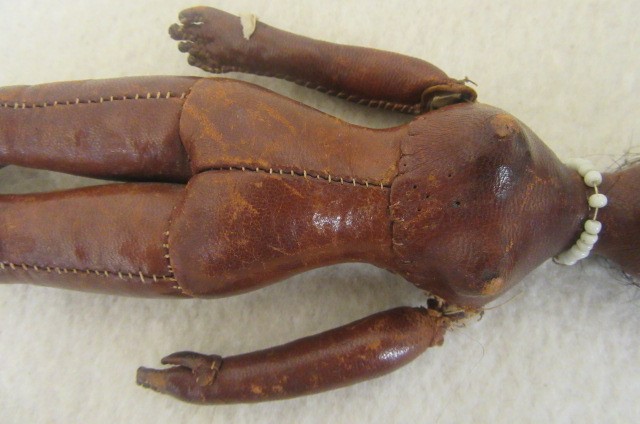 An early 19th century stitched leather doll with inset painted eyes Image