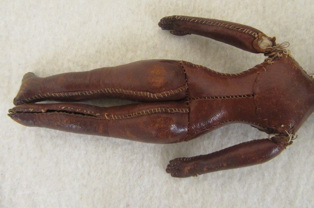 An early 19th century stitched leather doll with inset painted eyes Image