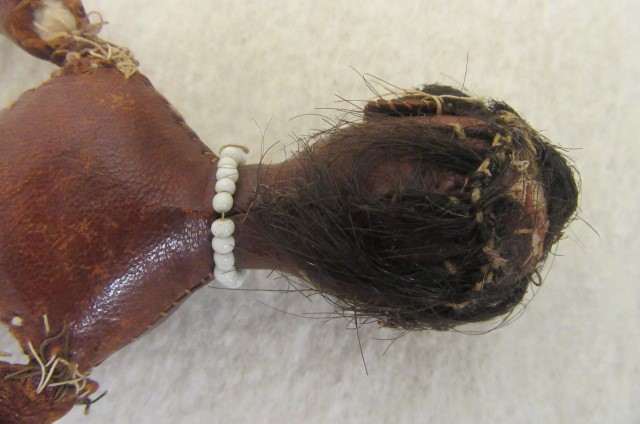 An early 19th century stitched leather doll with inset painted eyes Image