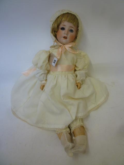 A Schoenau & Hoffmeister bisque head doll with blue glass sleeping eyes Image