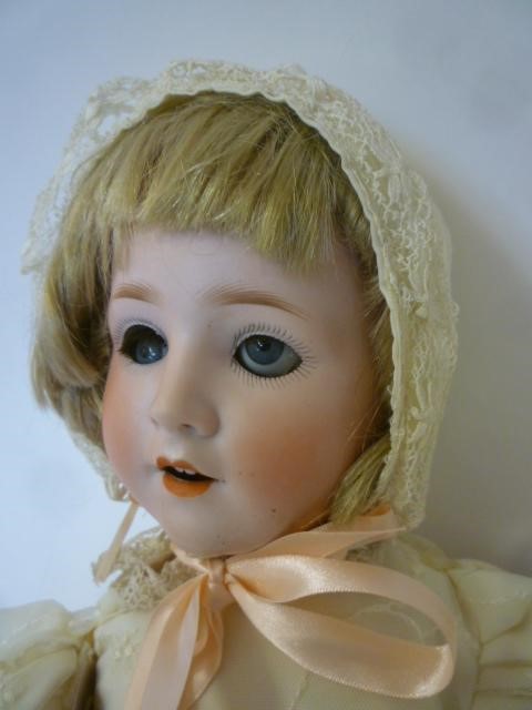 A Schoenau & Hoffmeister bisque head doll with blue glass sleeping eyes Image