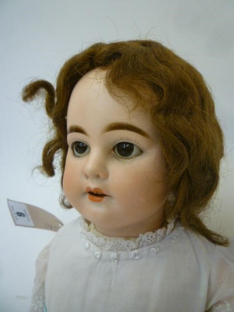 An Armand Marseille bisque head doll with brown glass sleeping eyes Image