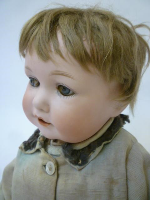 An Armand Marseille bisque head character doll with blue glass sleeping eyes Image