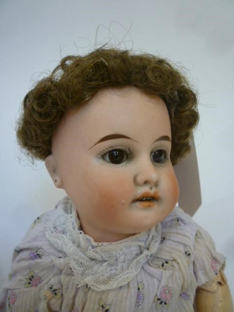 A Gebruder Kuhnlenz bisque head doll with brown sleeping glass eyes Image