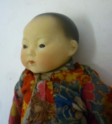 An Armand Marseille bisque head oriental baby doll with brown glass sleeping eyes Image