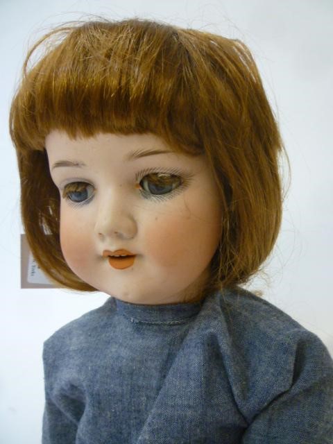 An Armand Marseille bisque head doll with blue glass sleeping eyes Image