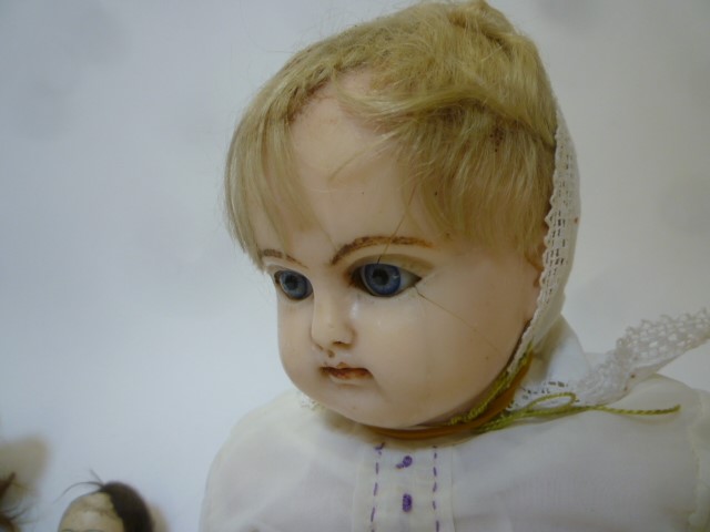 A wax covered shoulder head doll with blue glass sleeping eyes Image