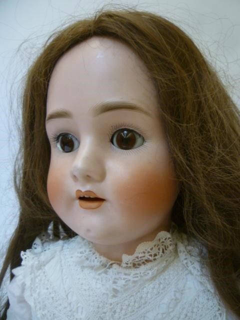 A large Schoenau & Hofmeister bisque head doll with brown glass sleeping eyes Image