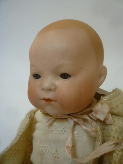 An Ernst Heubach bisque head baby doll with blue glass sleeping eyes Image